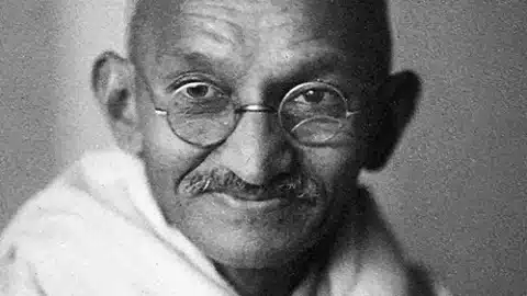 Photographie de Mahatma Gandhi avec ses lunettes emblématiques, symbole de simplicité et de non-violence, reflétant son engagement pour la justice sociale et l'indépendance de l'Inde.