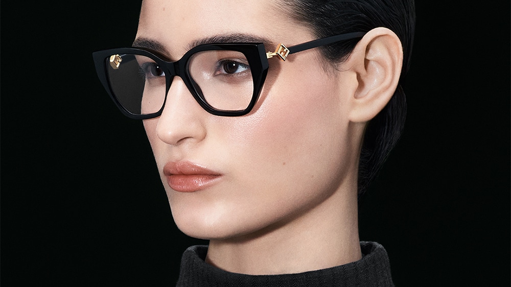 Thélios y FENDI. Las gafas FENDI FF Diamonds cuentan con una montura de acetato negro en forma de ojo de gato, decorada con un logotipo dorado en las varillas. Elegancia atemporal y estilo audaz, perfectas para un look sofisticado y moderno.