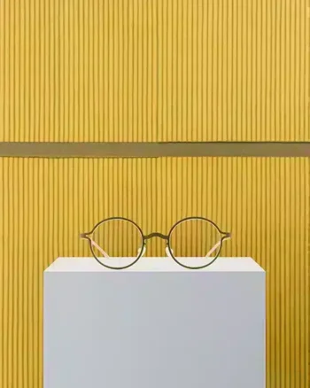 Gafas MYKITA Park Seo-Bo en dorado Golden Olive, sobre un fondo artístico
