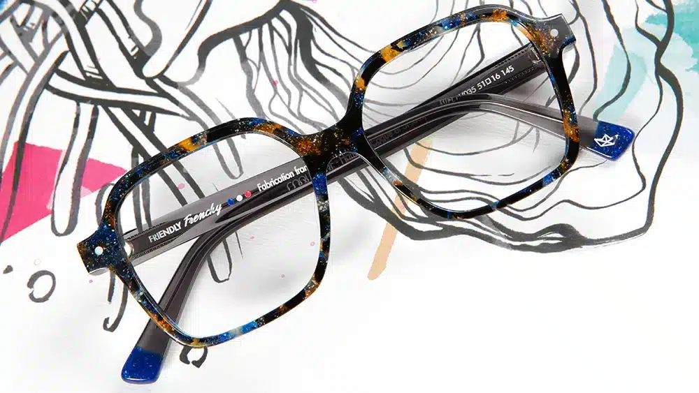 Lunettes Friendly Frenchy modèle Plie fabriquées en matériaux recyclés, posées sur un fond artistique