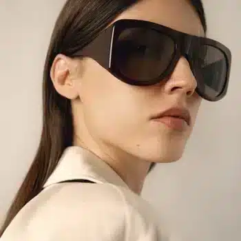 Mujer con gafas de sol KALEOS Haworth, diseño moderno y atrevido, montura marrón oscuro.