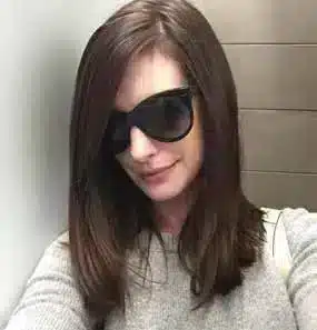 Anna Hathaway portant des lunettes de soleil Oliver Goldsmith Manhattan, un modèle iconique inspiré des années 60.