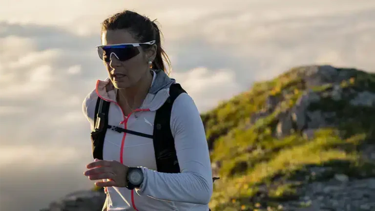 Femme pratiquant le trail running en montagne avec des lunettes Rudy Project Turbolence, offrant protection et stabilité.