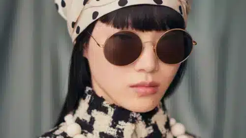 Parisee - Modèle portant des lunettes de soleil rondes Valentino de la collection "Avant les Débuts", avec un look rétro chic inspiré de la haute couture.